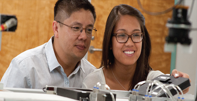 A student works with a professor in a lab