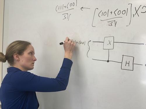 Dr. Hurst writing entangled states on whiteboard